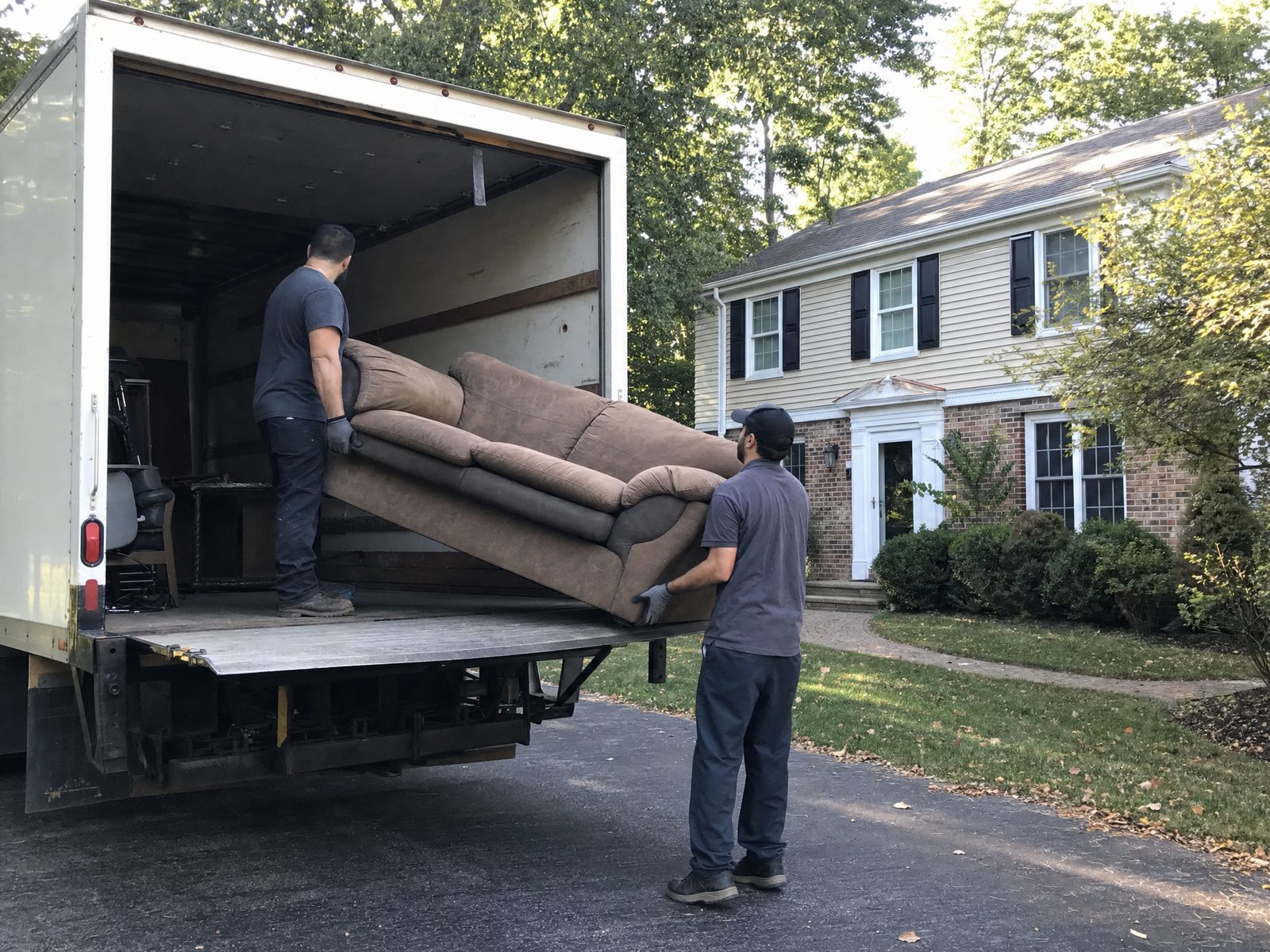 Orland Park Junk crew loading an old couch into the truck in a suburban Orland Park driveway